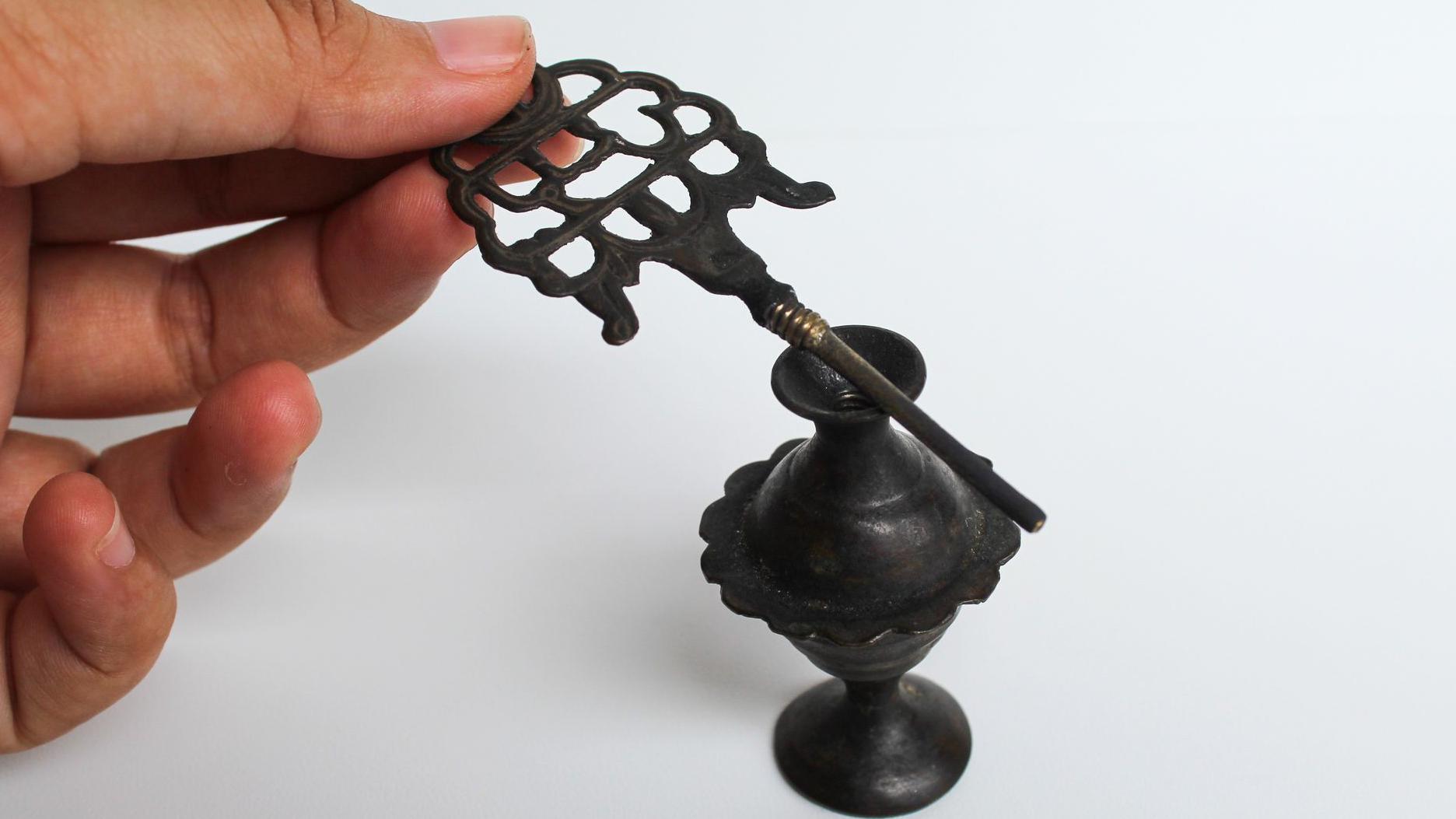 Ženska ruka u krupnom kadru drži antički pribor za nano&scaron;enje kajala i women's hand holding an old make up tool for Kohl eyeliner, and an old storage cup.