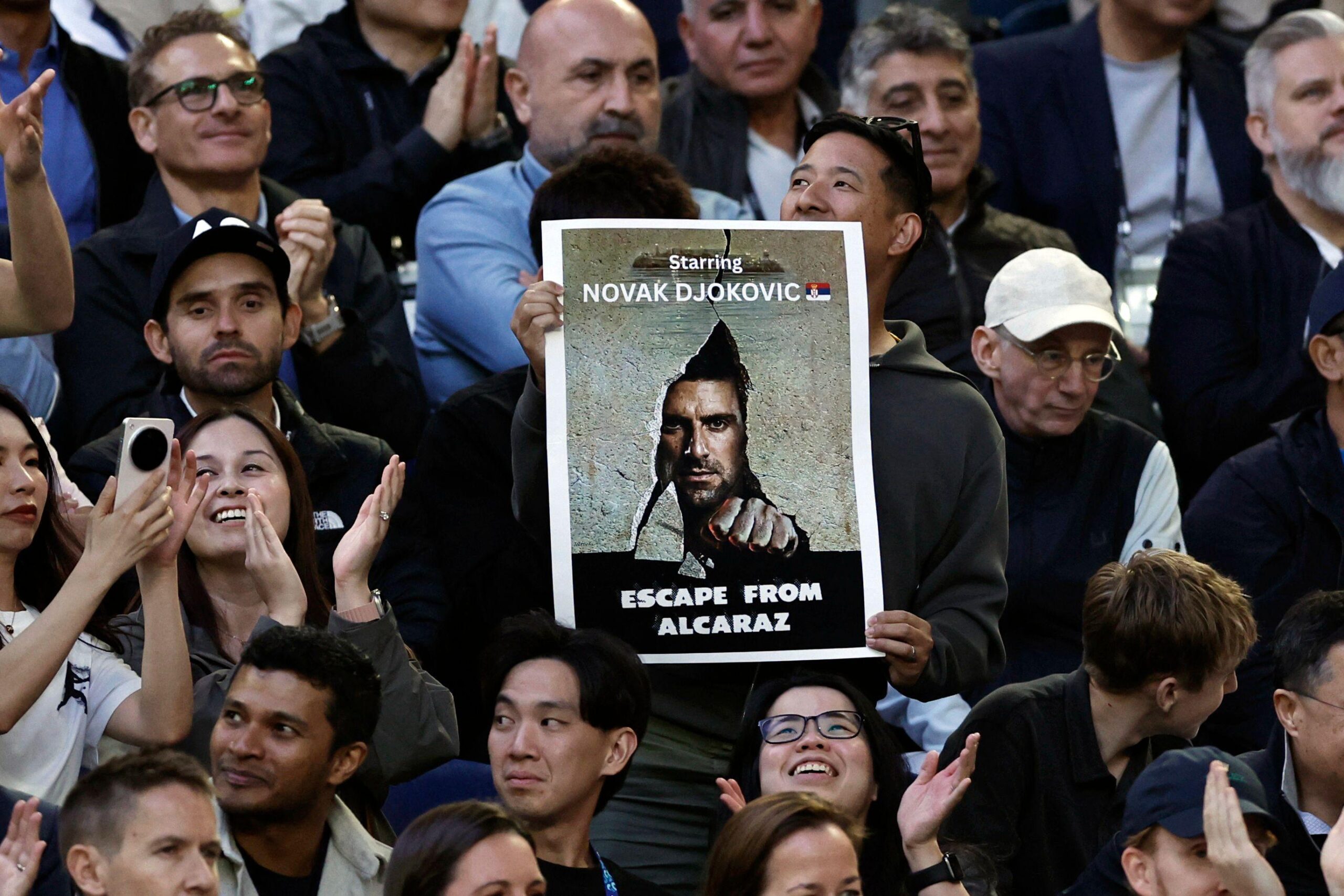 navijač novaka đokovića u melburnu, Đokovićev navijač u Melburnu drži zanimljiv transparent: Fotografija Novaka kao plakat za film i poruka: 'Bekstvo od Alkaraza'