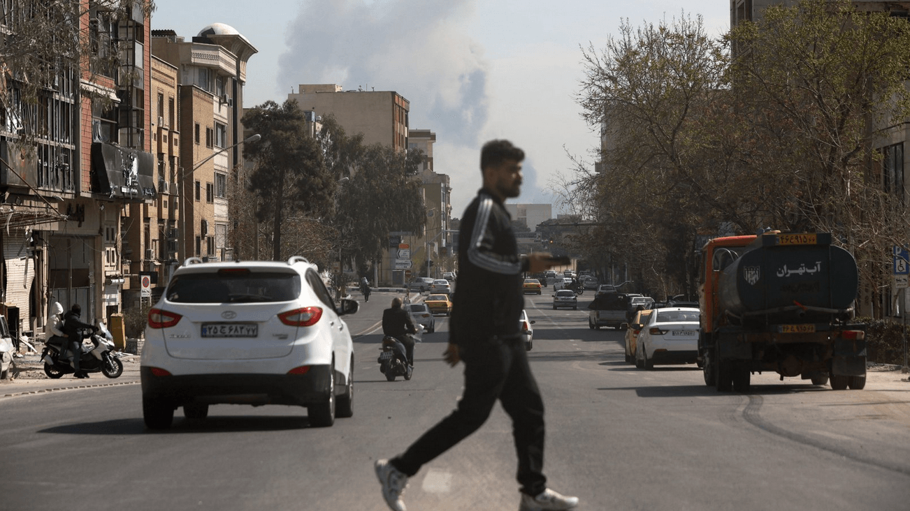 Mu&scaron;karac u tamnoj odeći prelazi ulicu u Teheranu