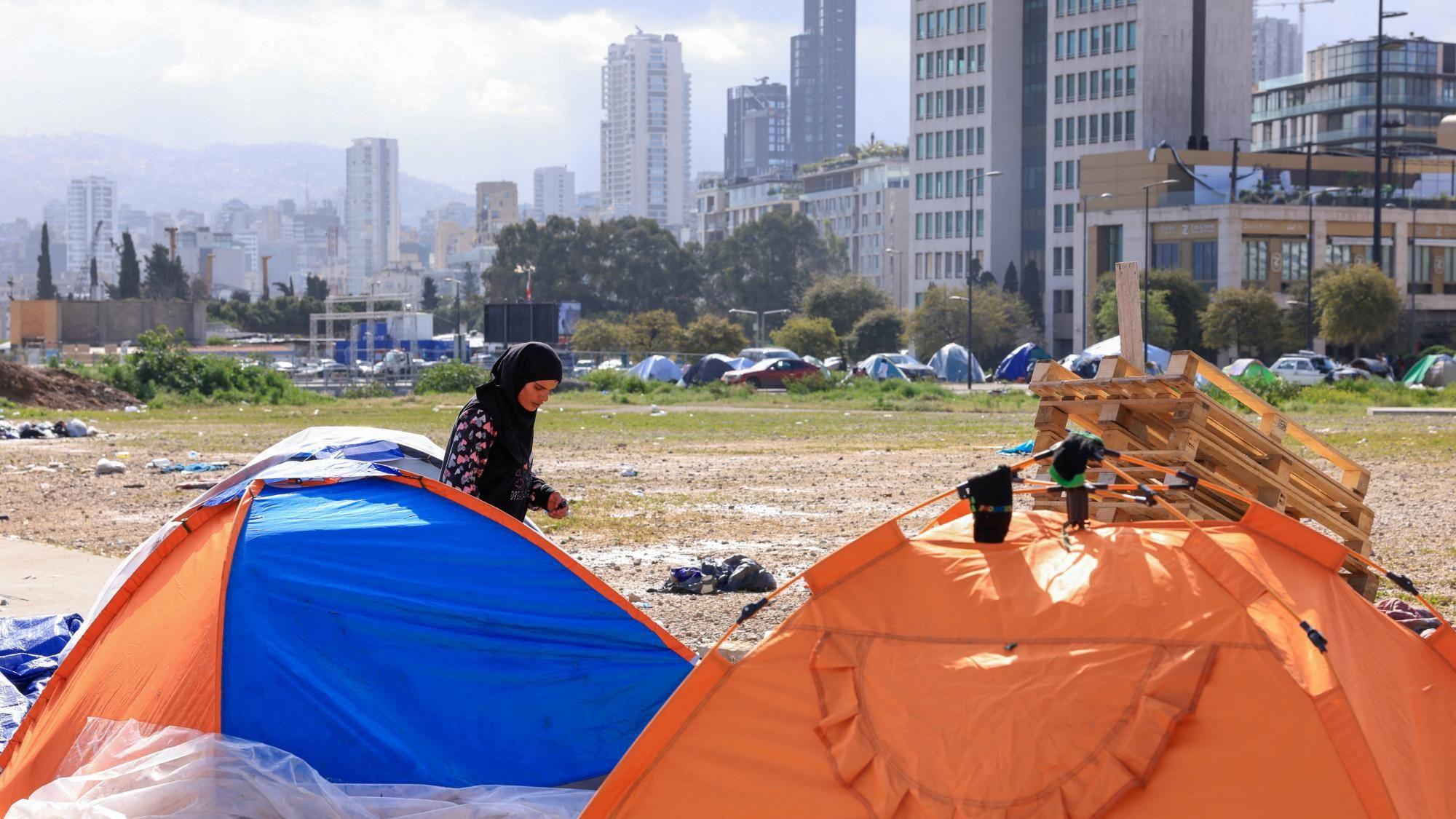 Žena &scaron;eta pored &scaron;atora koji se nalaze na poljani u gradu