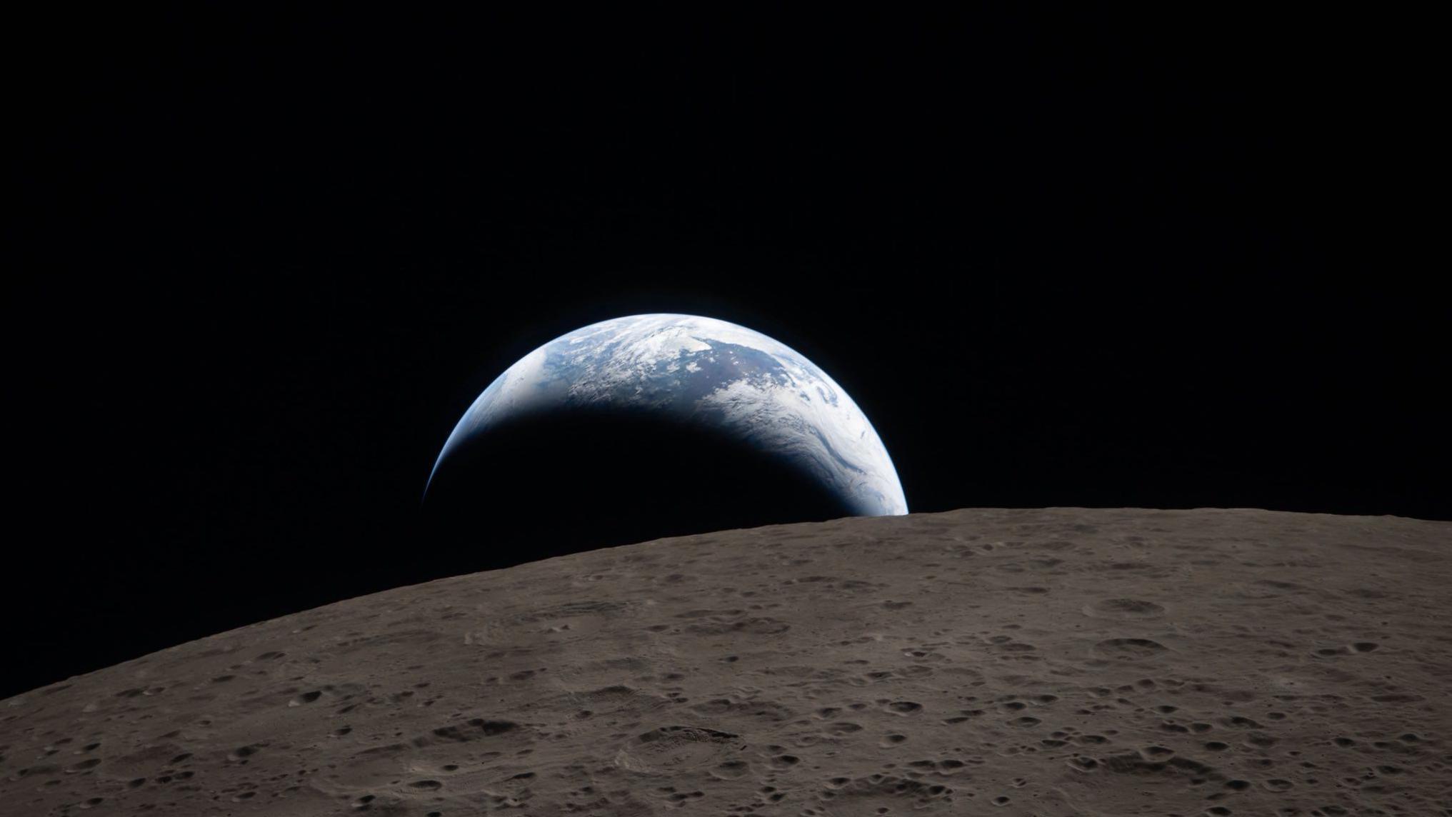 Zemlja se uzdiže iznad smeđe-sive povr&scaron;ine Meseca